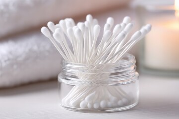 Cotton swabs in a glass jar on a bathroom counter, a symbol of personal hygiene and self-care, adding a touch of simplicity to the home spa experience.