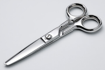 Obraz premium A close-up studio shot of professional hair cutting scissors on a clean white background, showcasing the craftsmanship and precision of the steel blades and ergonomic design.