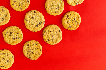 A row of chocolate chip cookies on a red background