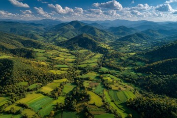 Fototapeta premium Lush Green Valley Surrounded by Majestic Mountains Under Blue Sky