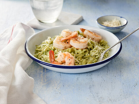 Delicious Pesto Orzo Topped With Garlic Shrimp Served on a Rustic Table