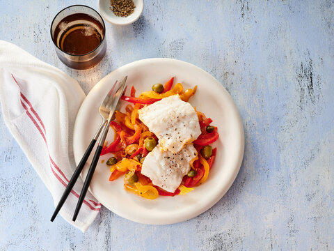 Cod Fillets Served on a Bed of Colorful Bell Peppers and Garlic for a Healthy Dining Experience
