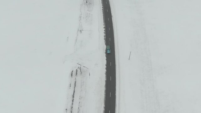 Aerial Drone Shot of Old Truck Driving Through Snowy Rural Landscape in Harsh Russian Winter
