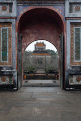 Open stone arch against the background of abandoned asian ancient buildings and antique ruins.  A mystical religious setting