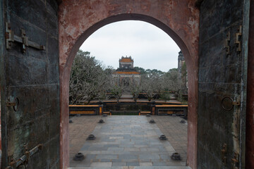 Open stone arch against the background of abandoned asian ancient buildings and antique ruins.  A mystical religious setting