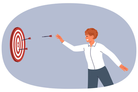 Business man is trying to hit target and achieve desired result by throwing darts at dartboard. Successful guy does not give up after first mistake and demonstrates perseverance in achieving target