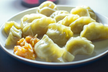 Side view of Momo, type of South Asian dumpling; native to Tibet, Nepal, Bhutan and Sikkim. It is similar to Chinese baozi and jiaozi, Mongolian buuz, Japanese gyoza and Korean mandu.Stock photograph.