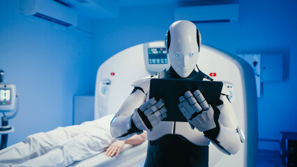 Futuristic humanoid robot holding tablet and analyzing patient medical data in high-tech diagnostic room. Robot standing in front of CT scanner while person lying motionless on examination bed.