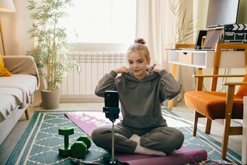 Teenage girl preparing for online fitness class at home