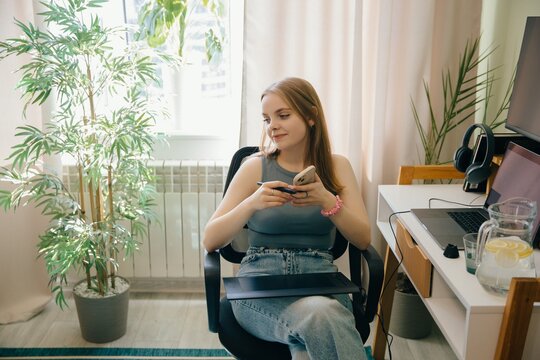 Young graphic designer working from home using graphics tablet and smartphone