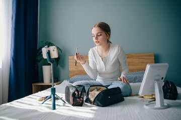 Teenager making beauty tutorial video from home bedroom