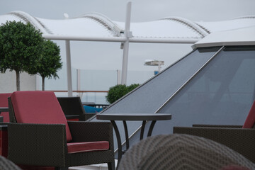 Outdoor whirlpool jacuzzi and private sun deck onboard modern luxury cruiseship cruise ship ocean liner with turquoise water, elegant rattan loungers and deck chairs for suite guests passengers