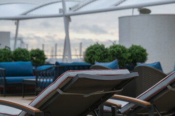 Outdoor whirlpool jacuzzi and private sun deck onboard modern luxury cruiseship cruise ship ocean liner with turquoise water, elegant rattan loungers and deck chairs for suite guests passengers