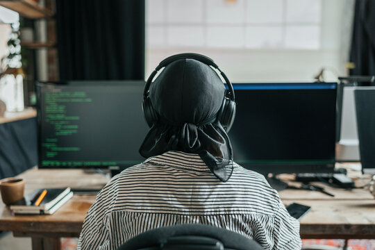 Rear view of female computer programmer doing coding at office