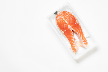 Salmon in plastic packaging on white background, fresh chilled fish