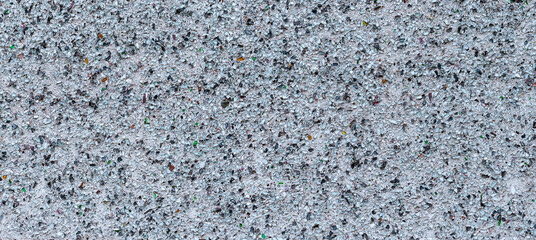 Wall surface with multicolored recycled glass inlays and a rough texture