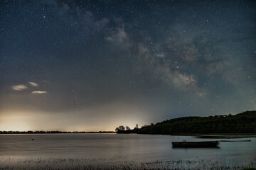 The Milky Way glows brilliantly over the still waters of Lake Kerkini, Greece