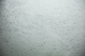 Raindrops hitting large body of water