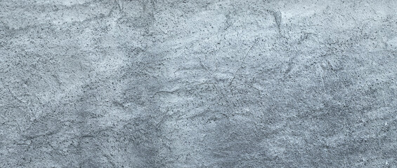 Textured surface of a light gray cement wall with a rough finish