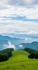 Obraz premium Serene green hilltop path leading to misty mountain range