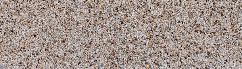 Panoramic texture of a wall with small pebbles and natural gravel