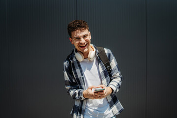 Portrait of a young adult man student smile using smartphone 
