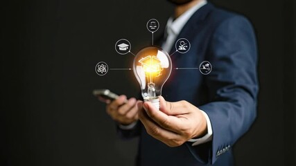 Executive holding illuminated light bulb with graduation cap inside in a darkened studio, educational icons circling idea and knowledge concept - Powered by Adobe