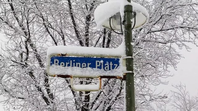 Street sign "Berliner Platz" in the city, winter time