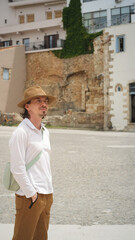 Tourist wearing hat exploring ancient ruins in greece