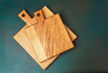 Wooden cutting boards stacked on a textured surface in natural light