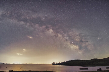 The Milky Way glows brilliantly over the still waters of Lake Kerkini, Greece