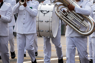 Bagpiper pay on acoustic drum and saxophone, walking on road