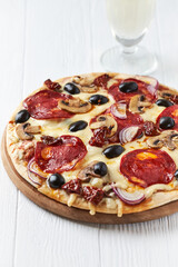 Pizza with chorizo ​​sausage, mozzarella and olives. Wooden background. Close up.