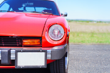 Front view of a red vintage car. Headlights. Classic car. Oldtimer. Sunny day.