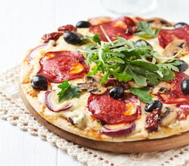 Pizza with chorizo ​​sausage, mozzarella and olives. Wooden background. Close up.