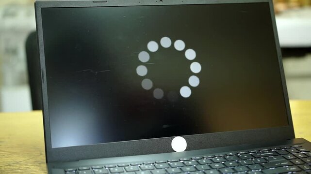 System error, slow loading, no connection to wifi on laptop screen in man hand. No signal internet connection on cellphone. System software update and upgrade loading process.