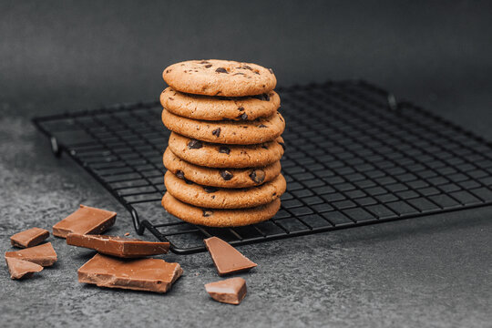 Freshly baked chocolate chip cookies stacked on a cooling rack - Powered by Adobe