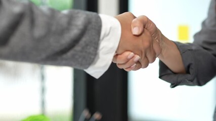 Hands of professional businessmen shaking hands successfully in business cooperation agreement, making a deal in modern office. - Powered by Adobe