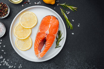 Fresh salmon steak prepared with lemon and herbs on a kitchen countertop