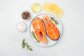 Fresh salmon fillets prepared with herbs, lemon, and spices on a kitchen surface