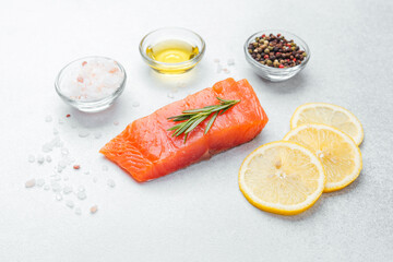 Fresh salmon fillet with lemon slices and seasonings ready for cooking