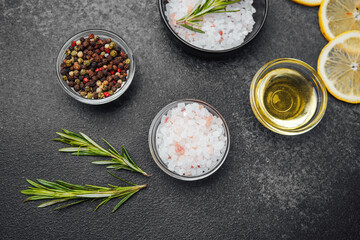 Various spices and herbs arranged on a dark kitchen countertop
