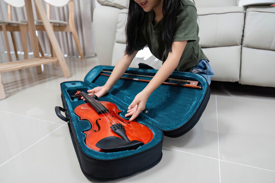 Excited Music Exploration. Girl discovering her new violin in its case.