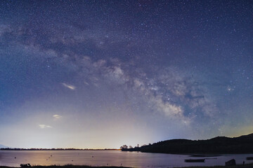 The Milky Way glows brilliantly over the still waters of Lake Kerkini, Greece