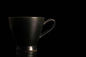One ceramic cup, close-up, isolated on black background.