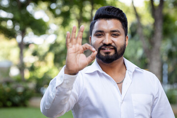 Confident South Asian young man showing approving, passing, good, yes, go for it, good to go, ok...