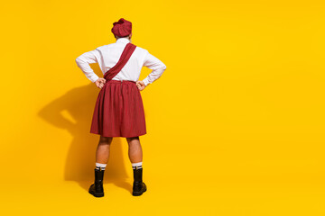 Man dressed in traditional Scottish kilt, posing against yellow background portraying culture and...