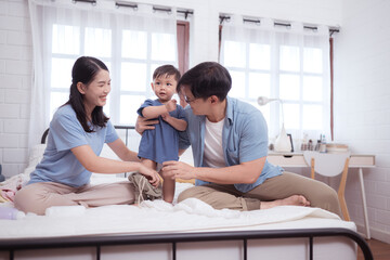 Fototapeta premium Asian kid and parents enjoying are having fun applying cream, powder and dressing up