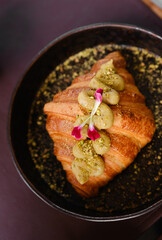 Delicious croissant topped with fruit and nuts served in an elegant setting
