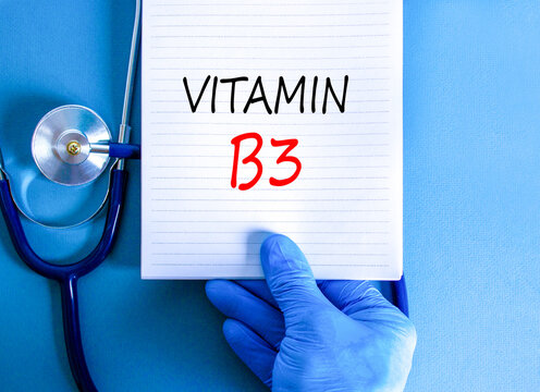 Vitamin B3 niacin symbol. Concept words Vitamin B3 on beautiful white note. Doctor's hand in blue medical glove. Beautiful blue background. Medical healthy lifestyle Vitamin B3 niacin concept.